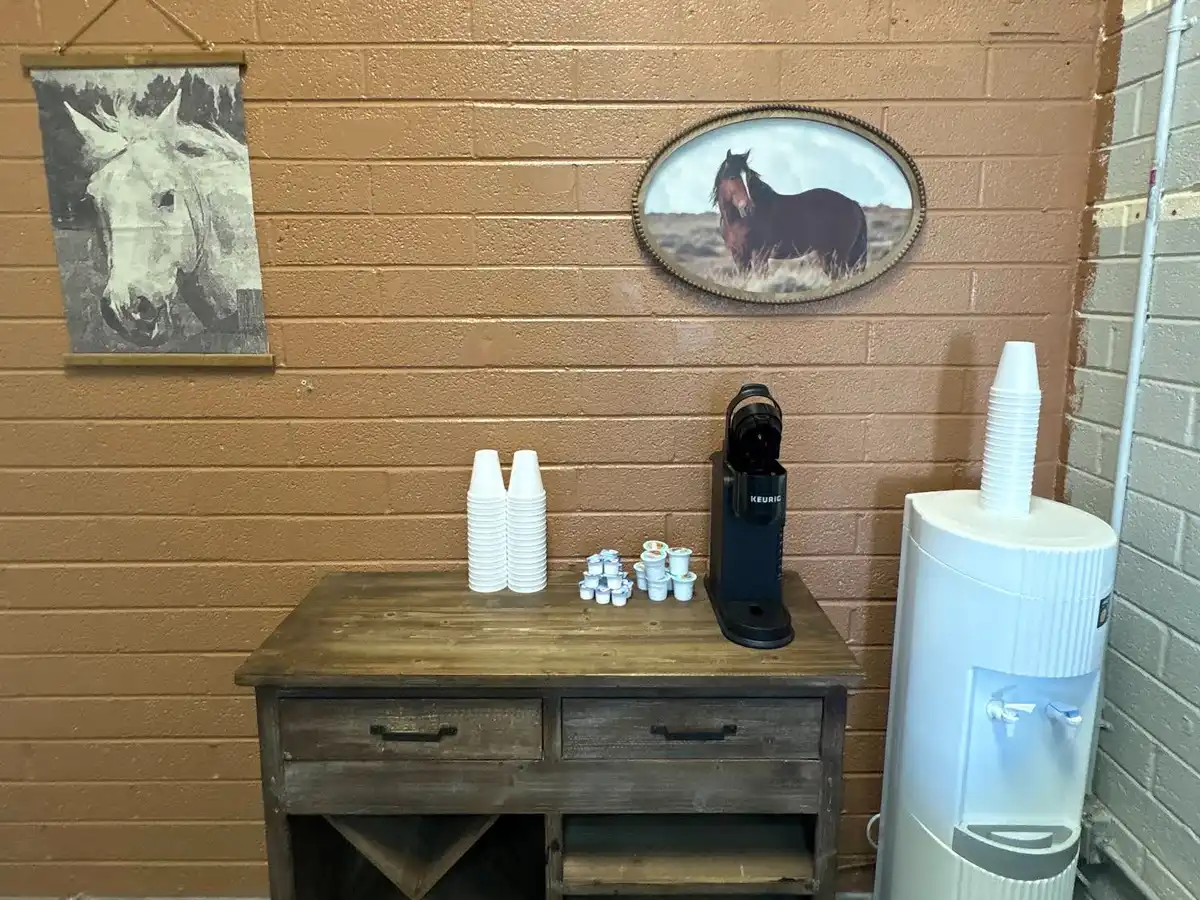 Coffee and water station on a rustic wood cabinet in the customer waiting area